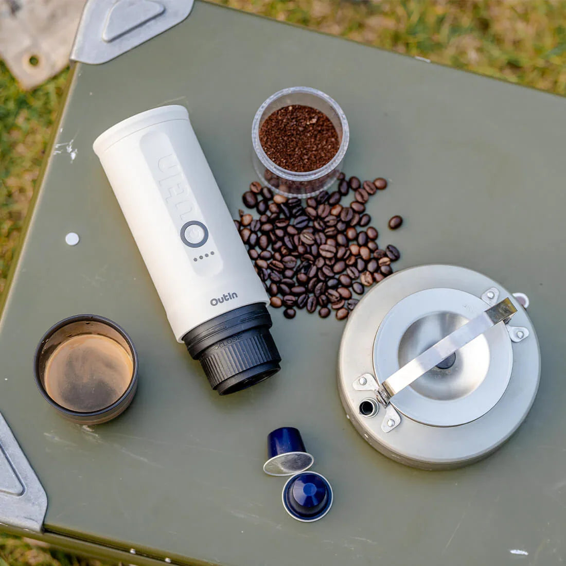 OutIn Nano held outdoors beside its coffee cup